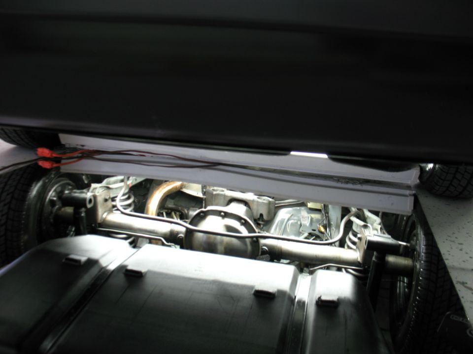 Rear axle and exhaust system of a vehicle, with "SUPERMOTORS" text visible