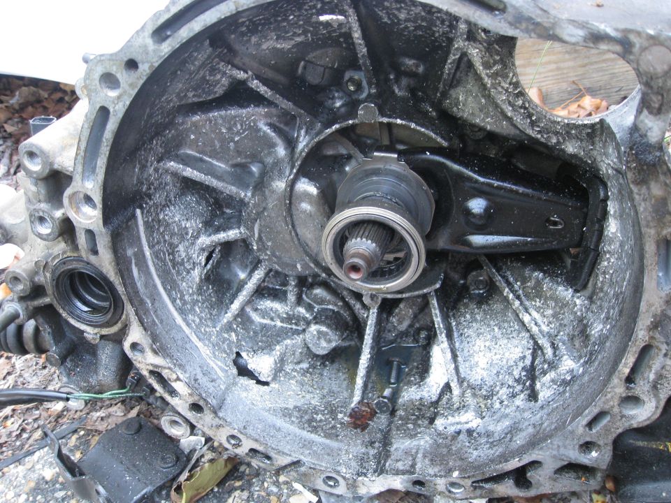 Transmission housing interior with splined shaft and clutch fork visible, covered in white residue