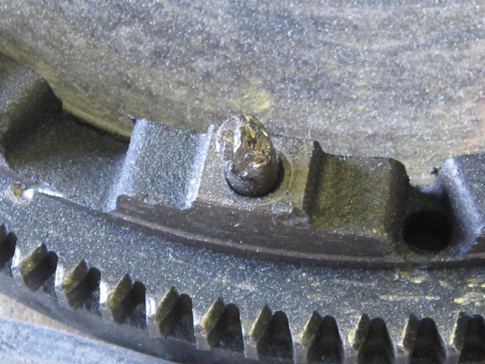 close-up of a damaged bolt on a toothed metal ring