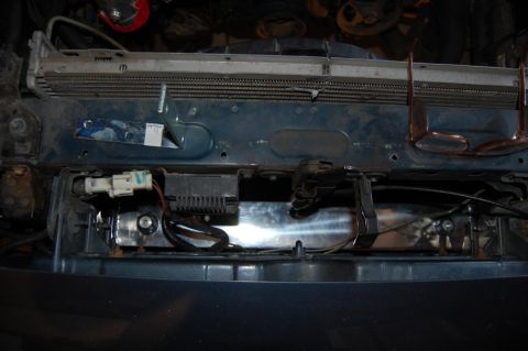 1985 Mercury Grand Marquis - Close-up view of the radiator support area in a vehicle's engine bay, showing various electrical connectors and wiring.