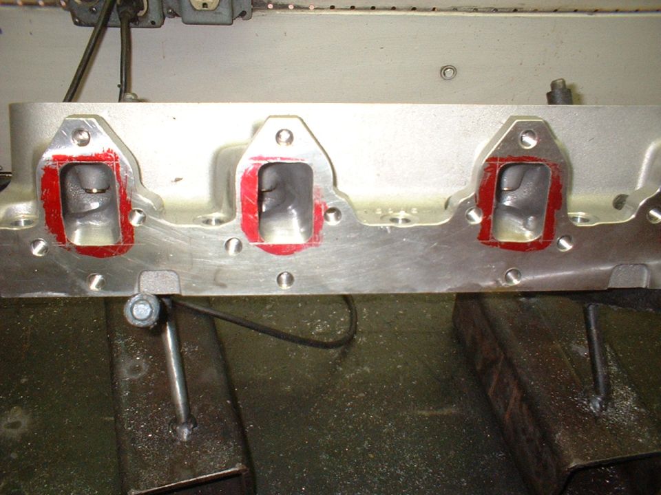 Close-up of an engine cylinder head with intake ports prepared for gasket installation