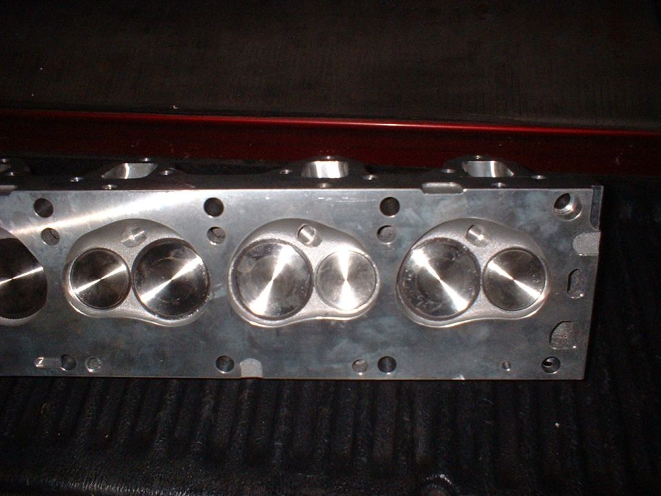 Aluminum engine cylinder head with visible valves and bolt holes