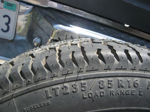 1986 Ford Bronco - Close-up of a spare tire and chrome bumper, with a license plate visible in the background.