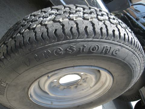 1986 Ford Bronco - A close-up view of a Firestone tire mounted on a vehicle's wheel.