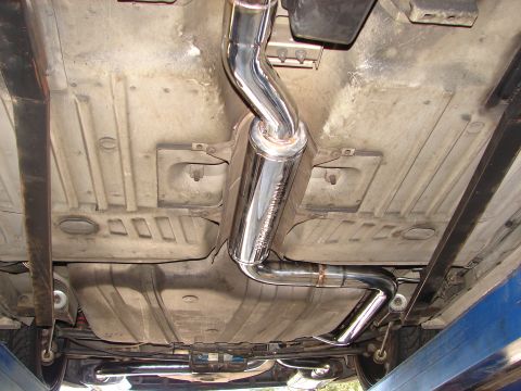 1992 Ford Taurus - The underside of a vehicle displays a shiny aftermarket exhaust system and its fuel tank.