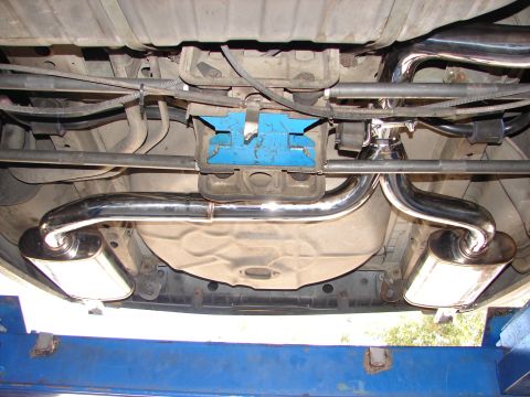 1992 Ford Taurus - Underside view of a vehicle's dual exhaust system, polished mufflers and piping.