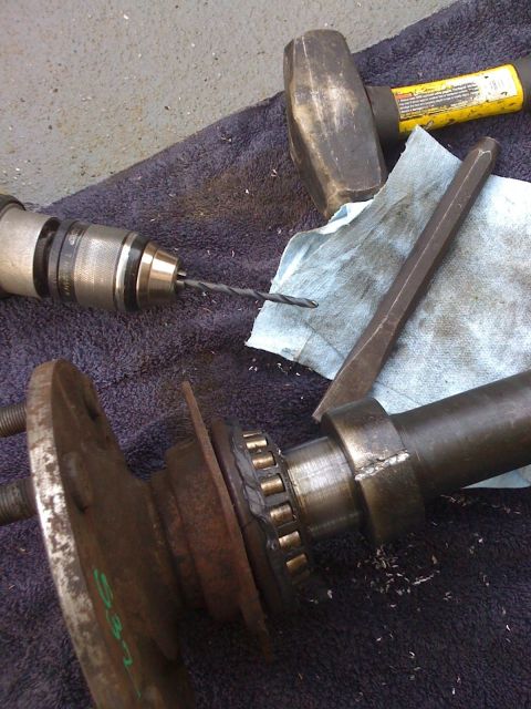 1989 Ford Bronco - Tools are laid out for working on an axle shaft, including a drill, hammer, and chisel.