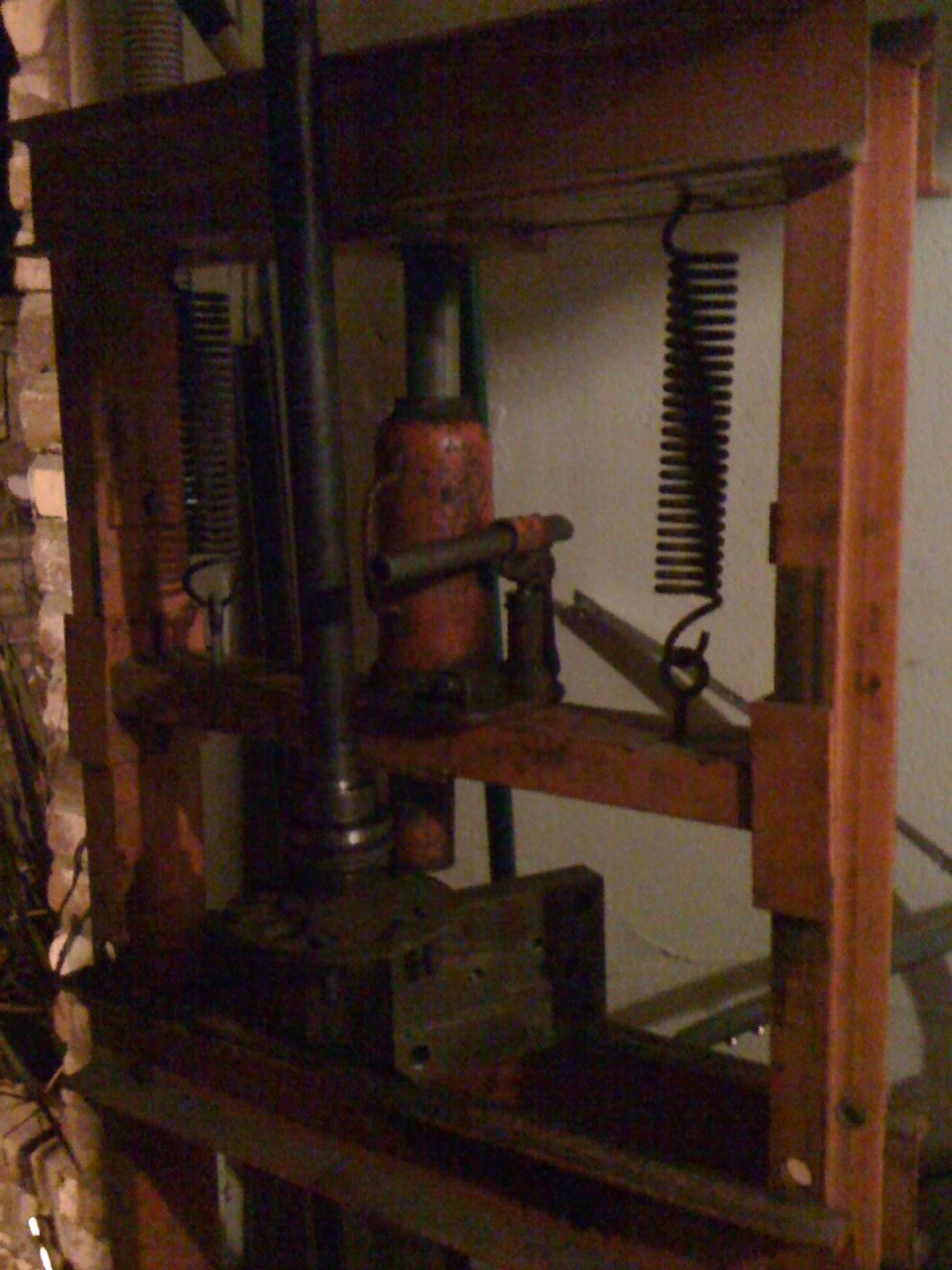 Hydraulic press with orange frame and red jack