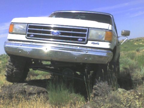 1989 Ford Bronco - This 1989 Ford Bronco is captured from the front, navigating a , rocky landscape with its 4x4 capabilities.