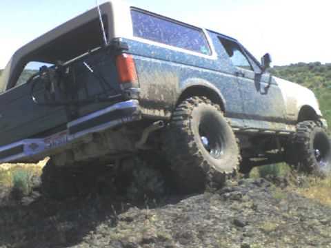 1989 Ford Bronco - Muddy 1989 Ford Bronco navigating an off-road trail.