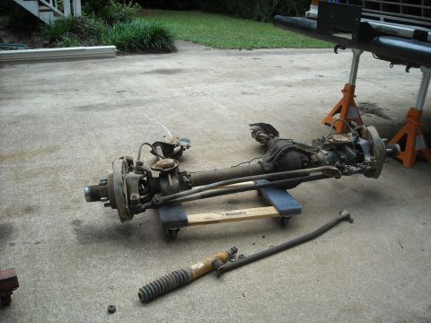 1979 Ford F-150 - Front axle assembly and related parts are laid out on a concrete surface.