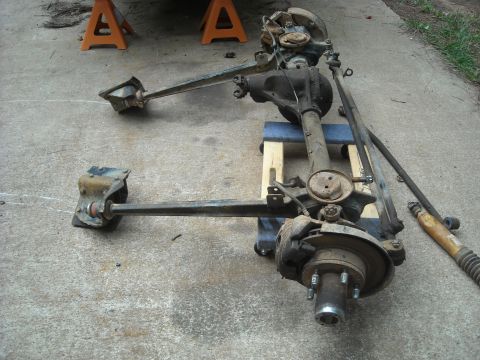 1979 Ford F-150 - Front axle assembly, likely from a truck, displayed on a concrete surface with jack stands in the background.