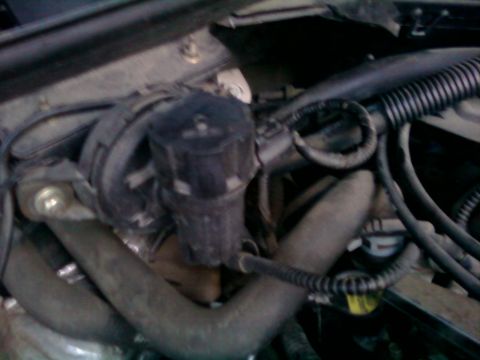 2000 Mercury Grand Marquis - Close-up view of engine bay components, including hoses and a black plastic part.