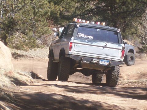 1978 Ford Bronco - A modified 1978 Ford Bronco navigates an off-road trail, kicking up dust as it goes.