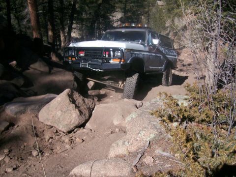 1978 Ford Bronco - This 1978 Ford Bronco is tackling a challenging off-road path with large rocks.