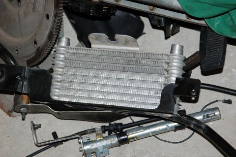 2007 Ford Mustang - An oil cooler is shown with a flywheel and other engine components in this close-up view.