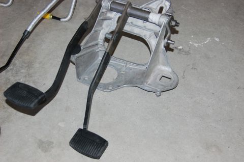 2007 Ford Mustang - A close-up view of a vehicle's clutch and brake pedal assembly, along with associated metal components and tubing.