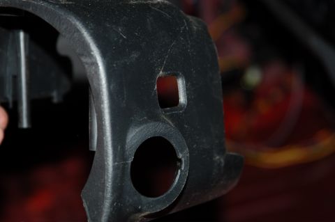 2007 Ford Mustang - Close-up of a black plastic interior trim piece, showing a circular cutout and a smaller square cutout.