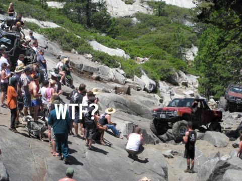 1989 Ford Bronco - Spectators gather to watch an off-road pickup truck navigate a challenging rocky trail.