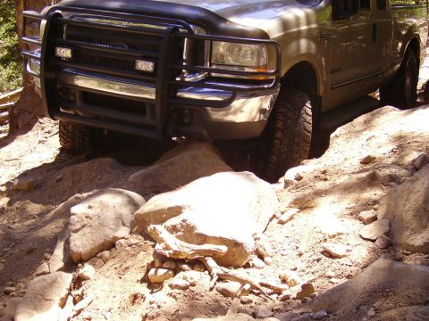 1978 Ford Bronco - Ford F-Series truck with brush guard navigating rocky terrain.