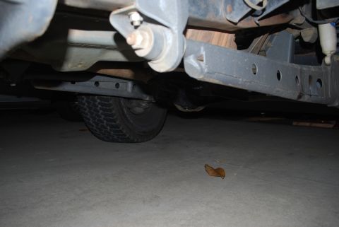 1996 Ford Bronco - The underside of a vehicle, showing suspension components and a tire, is captured from a low angle.