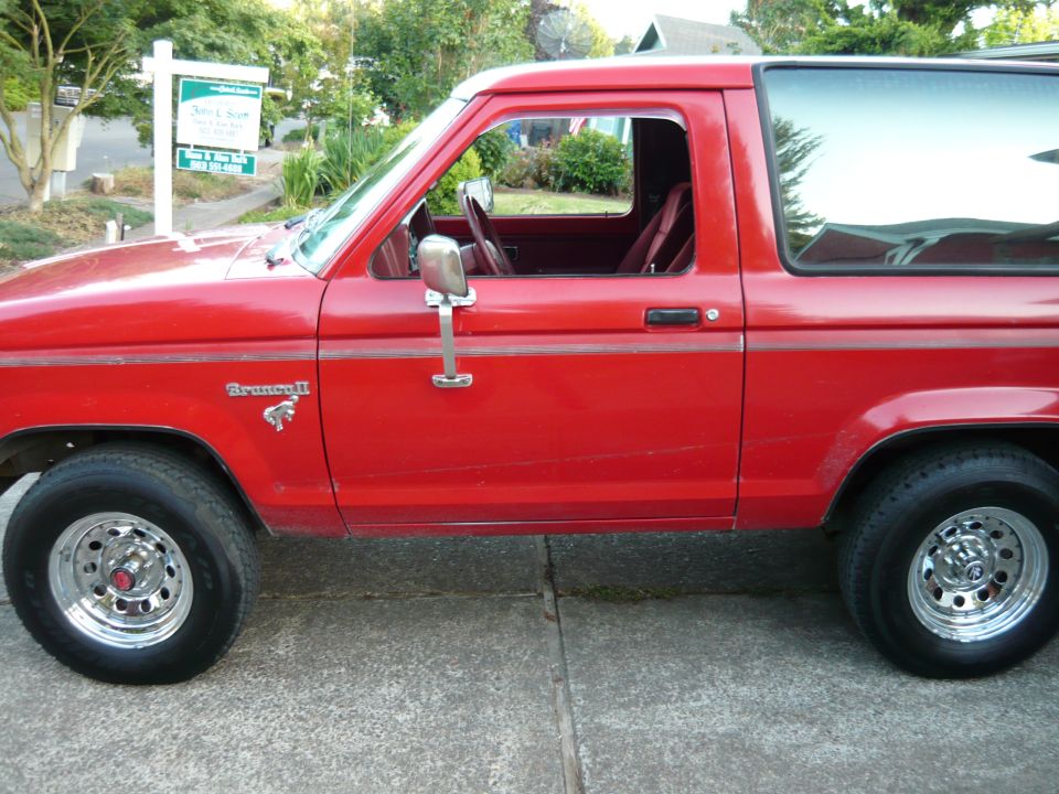 Red 1985 Ford Bronco II side view with 'Bronco II' badge visible