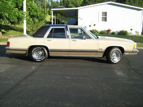 1988 Mercury Grand Marquis - This 1988 Mercury Grand Marquis is seen from the side, a tan body and a contrasting black vinyl roof.