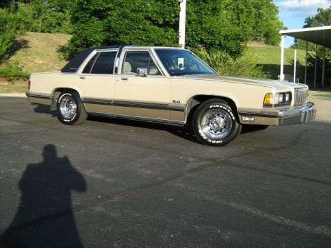 1988 Mercury Grand Marquis - This 1988 Mercury Grand Marquis sedan features a two-tone tan and brown paint scheme with a black vinyl roof.