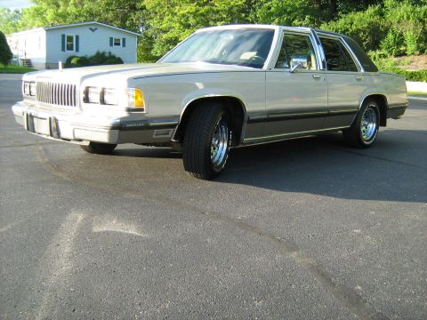 1988 Mercury Grand Marquis - This 1988 Mercury Grand Marquis features a distinctive grille and chrome accents, with a vinyl roof adding to its classic look.
