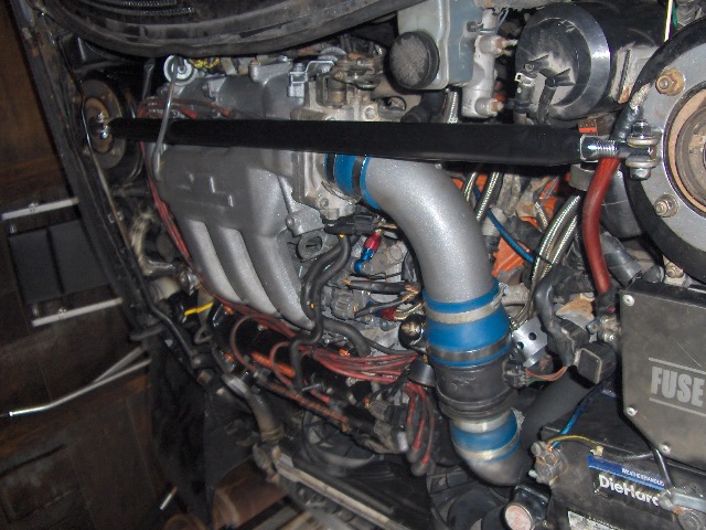 Engine bay with custom intake piping and blue accents