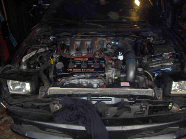 Engine bay with V6 DOHC 24-VALVE engine, battery, and radiator visible