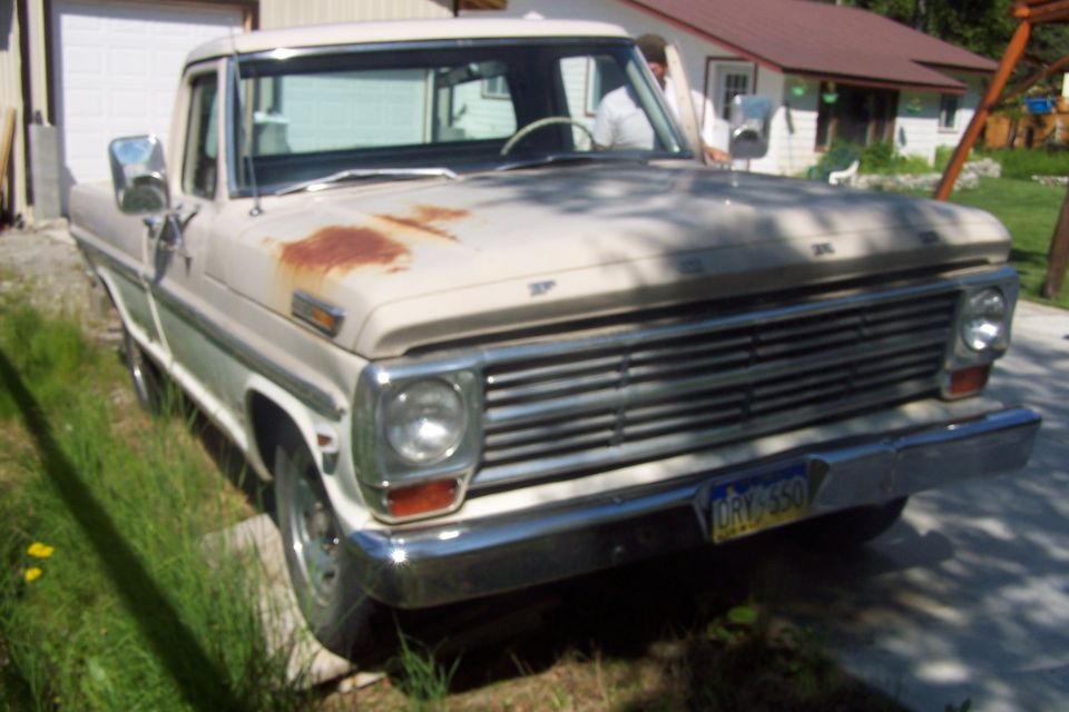 Old Ford F-Series pickup truck with rusty hood and chrome grille