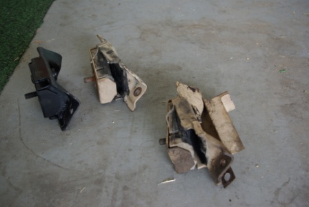 1995 Ford Bronco - Three engine mounts are shown on a concrete surface; two appear damaged.