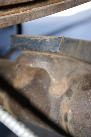 1995 Ford Bronco - Close-up view of a heavily rusted metal component, possibly from a vehicle's suspension system, with a watermark visible.