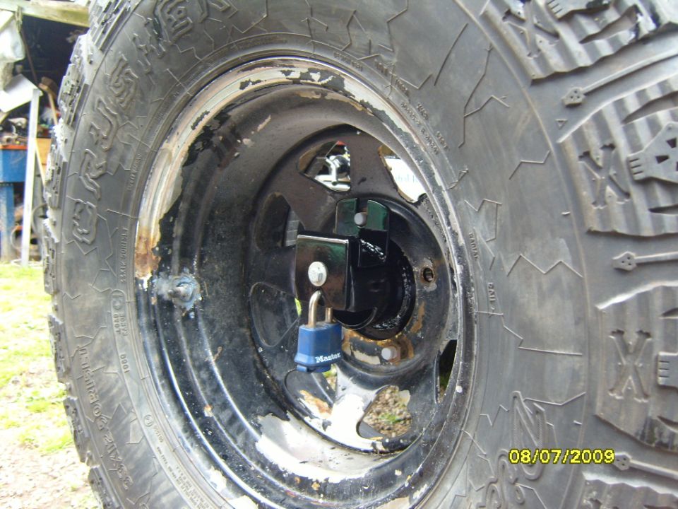 Spare tire with a Master Lock wheel lock attached to the lug nuts