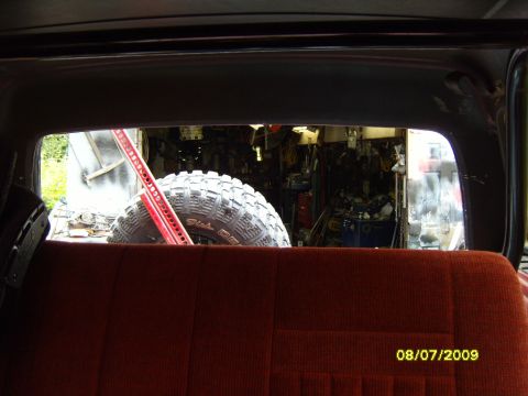 1989 Ford Bronco - View from inside a vehicle shows a large spare tire and a jack in a garage, with a date stamp of 08/07/2009.