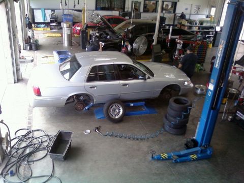 2000 Mercury Grand Marquis - Silver 2000 Mercury Grand Marquis undergoing service in a garage, with another vehicle being worked on.