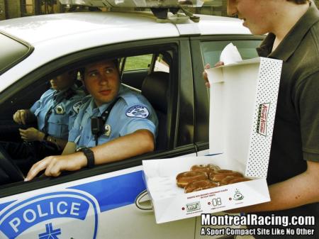 1993 Ford Taurus - A person offers a box of donuts to two police officers sitting in their patrol car.