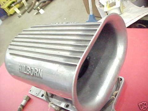 1972 Ford Ranchero - A Hilborn fuel injection scoop is shown on a red surface with other parts in the background.