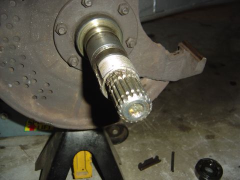 1986 Ford Bronco - Close-up view of a front wheel bearing assembly and splined axle shaft, likely undergoing maintenance.