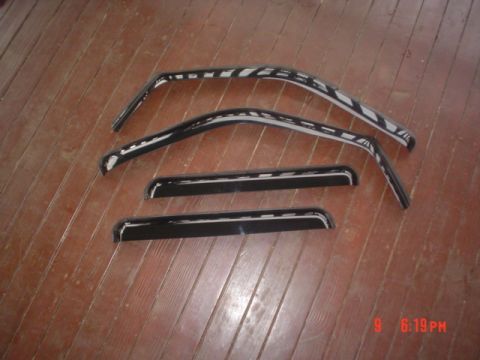 2005 Ford Excursion - Four window visors, two for front windows and two for rear, are laid out on a wooden floor.