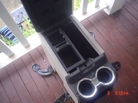 2005 Ford Excursion - The removed center console features multiple storage bins and dual cup holders with chrome accents.