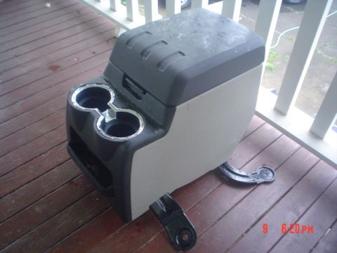 2005 Ford Excursion - This vehicle part, a center console, is shown outdoors on a wooden deck.