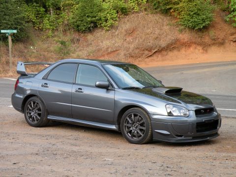1998 Subaru Legacy - A gray Subaru Impreza WRX STI sedan is parked on the side of a rural road.