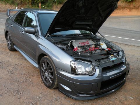 1998 Subaru Legacy - This Subaru WRX STI has its hood open, revealing the engine and intercooler. The car features aftermarket modifications.