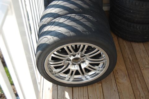 2002 BMW M3 - A set of performance tires and alloy wheels are stacked on a wooden deck.