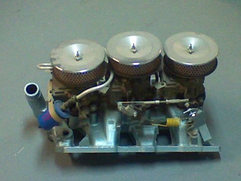 1974 Ford Ranchero - A triple carburetor assembly with chrome air cleaners is shown against a neutral background.