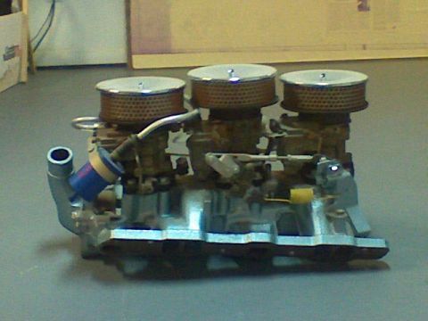 1974 Ford Ranchero - A triple carburetor setup with chrome air cleaners is shown, likely a performance upgrade for a vehicle.