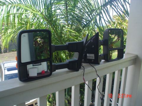 2005 Ford Excursion - A pair of side mirrors, likely for a truck, are displayed outdoors against a backdrop of lush greenery.