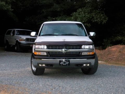 2002 Chevrolet Silverado 1500 - A white 2002 Chevrolet Silverado 1500 is parked in front of a Ford Bronco at dusk.